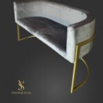 Сірий диван Loft Oval з м’якою велюровою оббивкою та золотою металевою основою на темному фоні. Стильний диван для салону краси, рецепції, зони очікування або сучасного інтер’єру.
