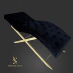 Анатомічна кушетка Loft у синьому велюрі з каретною прошивкою та золотим металевим каркасом для салону краси.